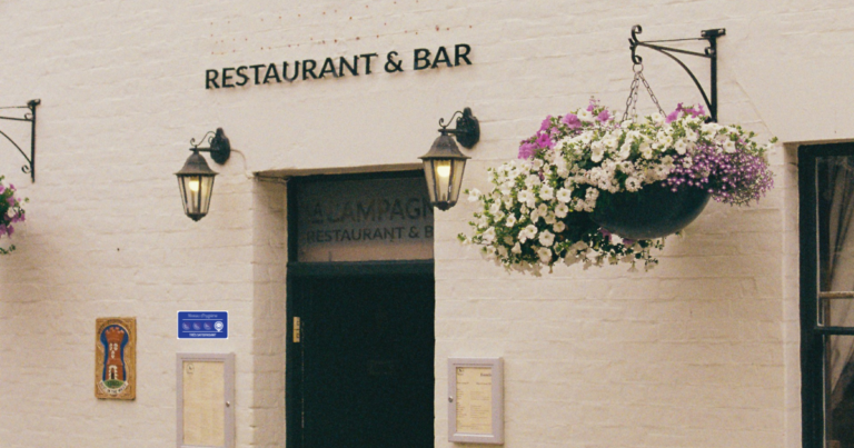 Façade de restaurant avec enseigne et porte peinte et affiche Alim'confiance - Unsplash