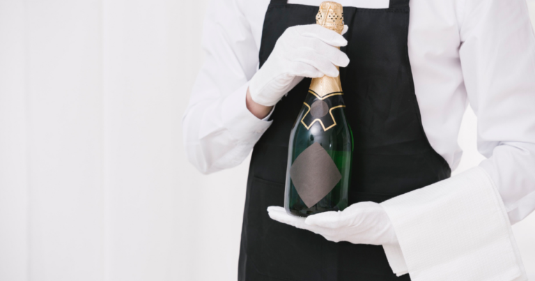 Main gantée tenant une bouteille avec précaution - Unsplash