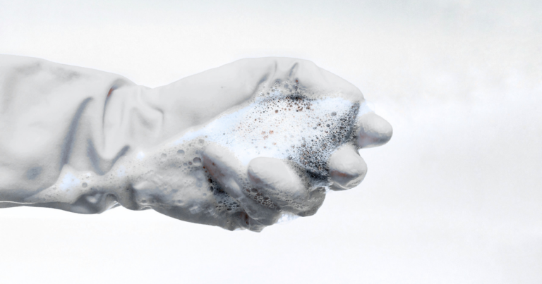 Main gantée couverte de mousse, geste de nettoyage - Unsplash
