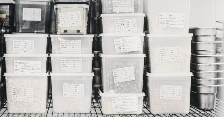 Bacs alimentaires empilés, étiquetés à la main avec dates de conservation - Unsplash