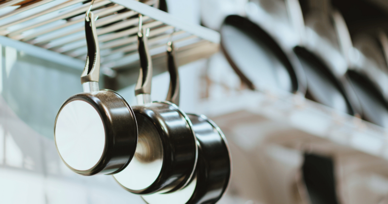 Poêles suspendues, gros plan sur les reflets métalliques - Unsplash