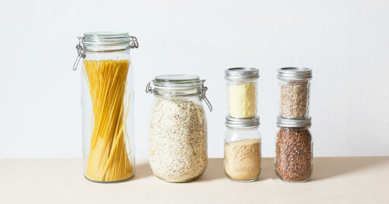 Bocaux de pâtes et de céréales alignés sur une étagère - Unsplash
