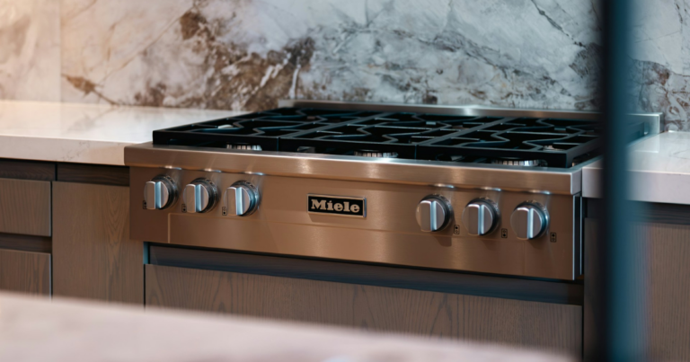 Cuisinière professionnelle en inox devant un plan de travail en marbre - Unsplash